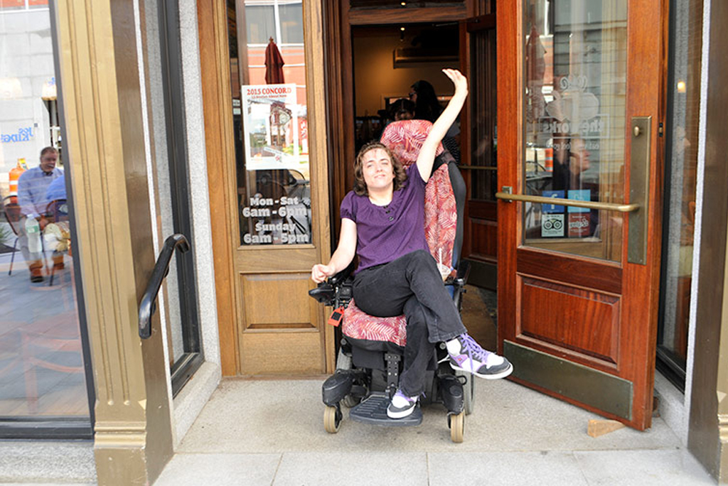 Woman in wheelchair exiting newly accessible cafe
