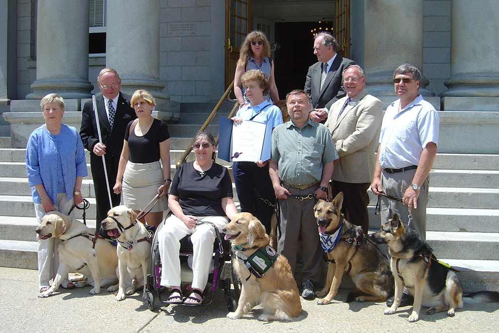 group of people with their service dogs