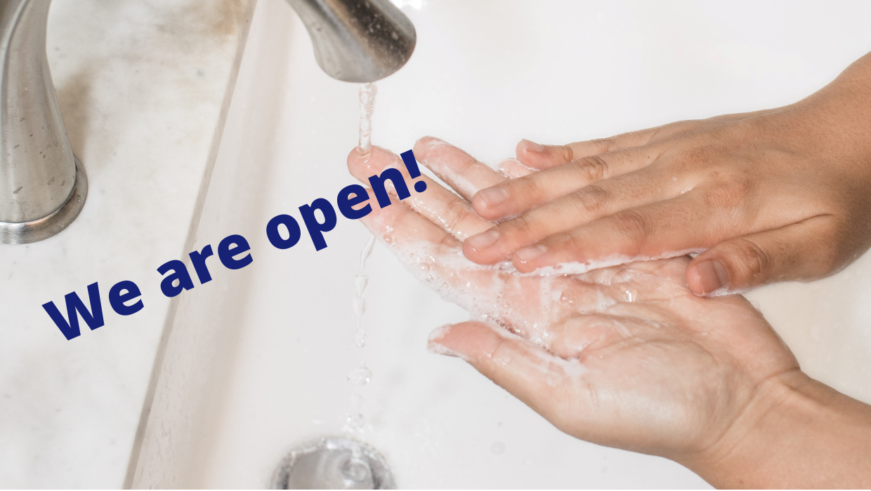 Close up of washing hands with text reading "We are open!"