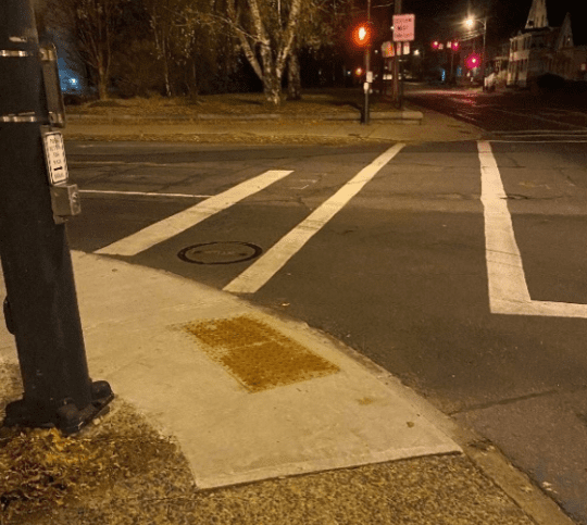 close up of a tactile pad and crosswalk at an intersection