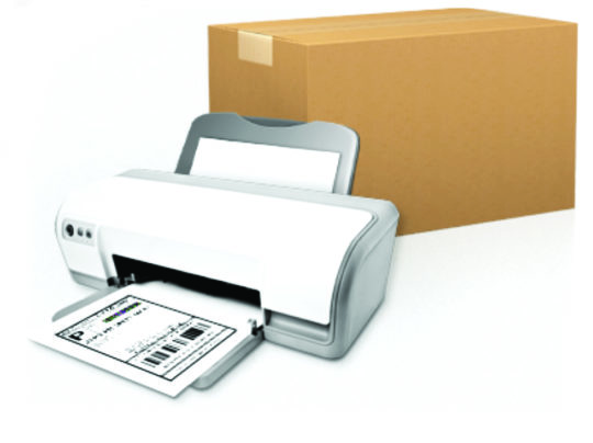 A printer prints out a shipping label and a large cardboard box sits behind it.