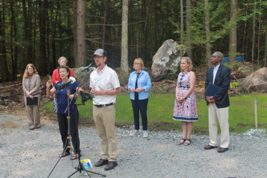 Mark Zankel, State Director, The Nature Conservancy in New Hampshire speaking at the groundbreaking event accompanied by an ASL interpreter. Stephanie Patrick, Executive Director, Disability Rights Center - New Hampshire, Kim Thibeault, Manchester Resident &amp; Granite State Independent Living Employee, Senator Maggie Hassan, Manchester Mayor Joyce Craig, and James McKim, President, NAACP of Greater Manchester all look on.