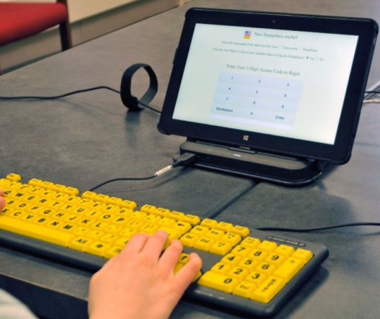One4all accessible voting system with tablet and yellow keyboard on a table.